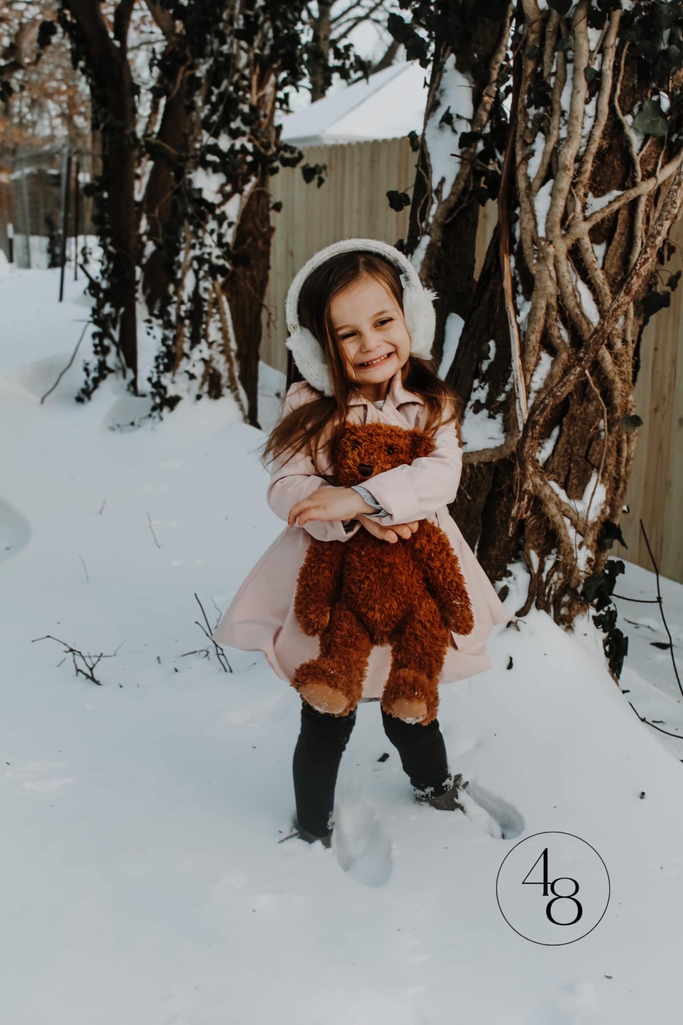 winter photoshoot, toddler girl with teddy bear prop in snow